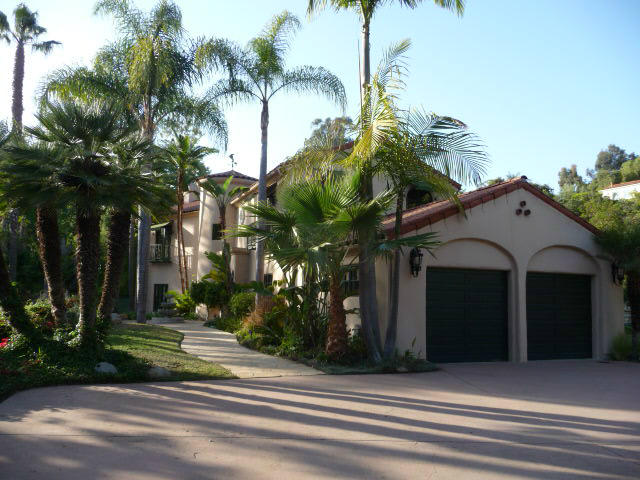a view of a house with a yard and potted plants