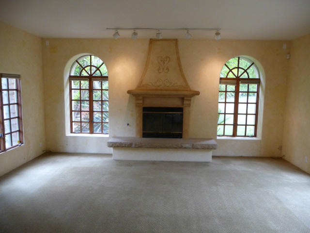 1845 Eucalyptus Hill Road Santa Barbara, CA 93108 - Photo 12 of 13 an empty room with windows fireplace and fans