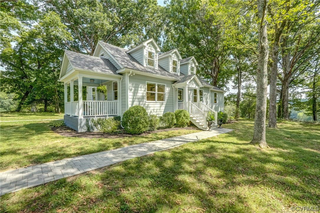 a view of a house with a big yard and large trees