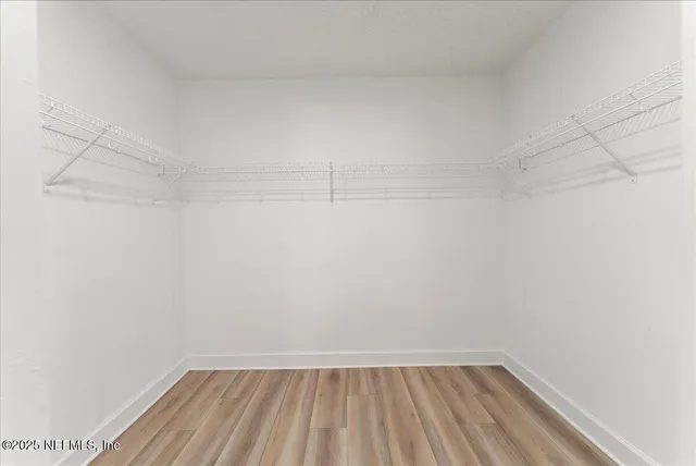 a spacious bathroom with a double vanity sink a mirror a toilet and a shower