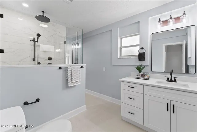 an empty room with wooden floor a ceiling fan and windows