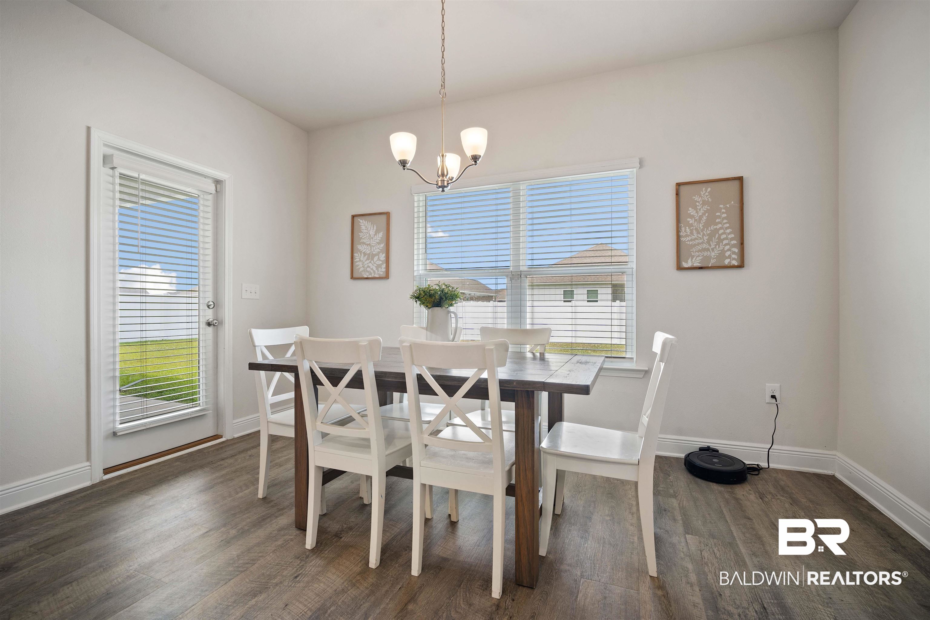 11021 Native Dancer Way Daphne, AL 36526 - Photo 9 of 35 Dining room featuring baseboards, dark wood-style floors, and an inviting chandelier