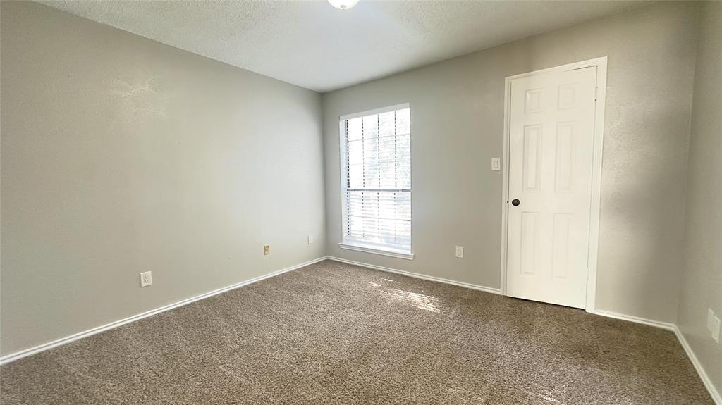 9601 Forest Lane, Unit 323 Dallas, TX 75243 - Photo 11 of 23 Unfurnished room with carpet and a textured ceiling
