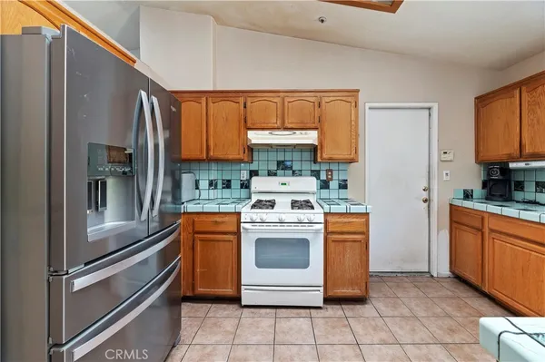 a kitchen with stainless steel appliances granite countertop a stove a refrigerator and a stove