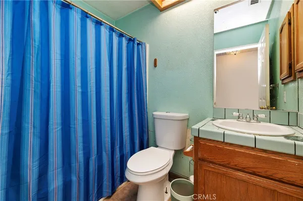 a bathroom with a toilet a sink and mirror