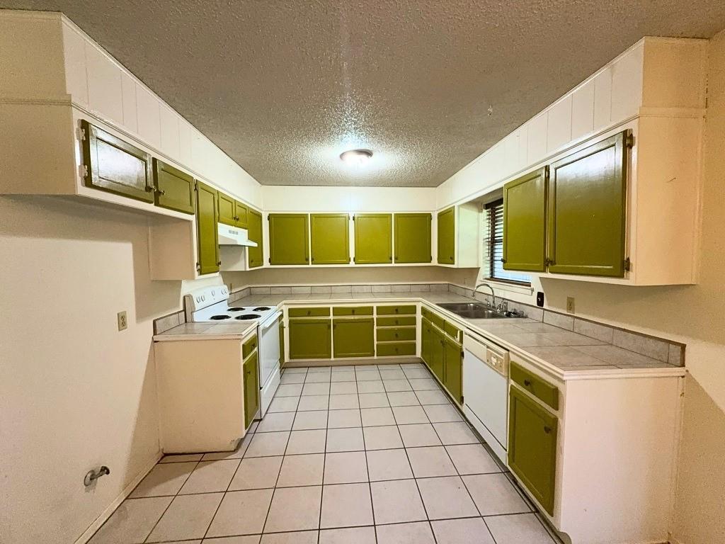 1613 Edgehill Road Benbrook, TX 76126 - Photo 6 of 22 a kitchen with stainless steel appliances granite countertop a stove a sink and a refrigerator
