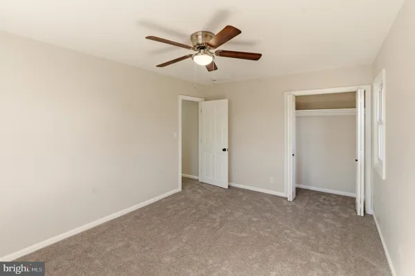 an empty room with windows and closet