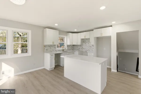 a large white kitchen with a stove a sink dishwasher and a refrigerator