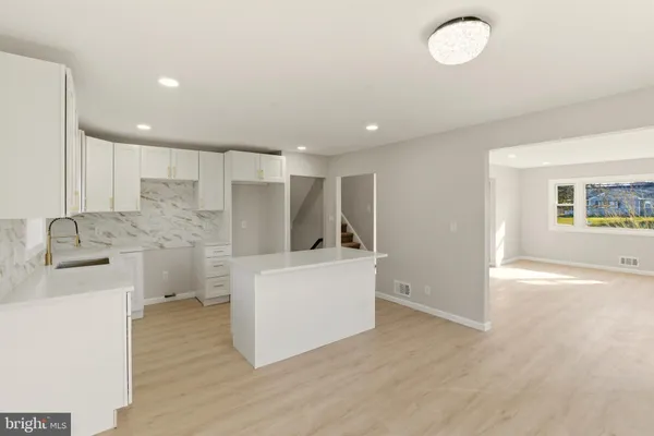 a kitchen with stainless steel appliances a refrigerator sink and white cabinets