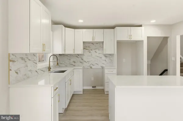 a kitchen with white cabinets and sink