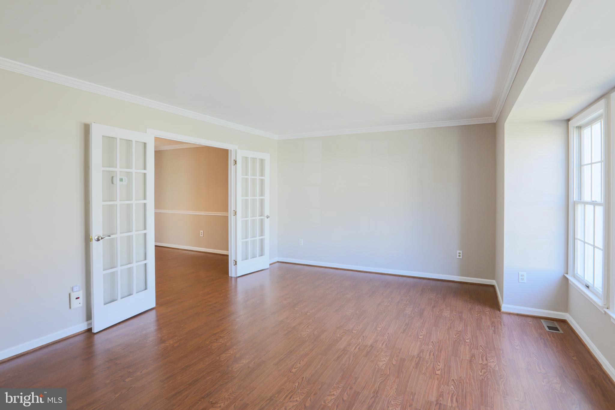 9547 Hallhurst Road Baltimore, MD 21236 - Photo 3 of 49 an empty room with wooden floor and windows