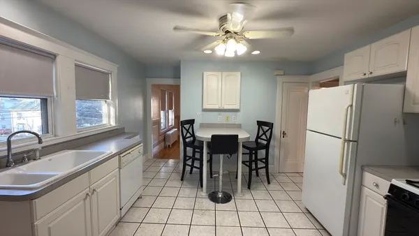 a kitchen with stainless steel appliances a refrigerator a sink a stove and white cabinets