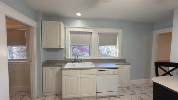 a kitchen with white cabinets and sink