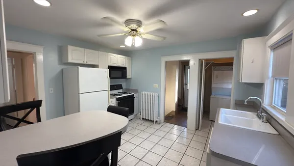 a kitchen with a refrigerator a sink cabinets and wooden floor
