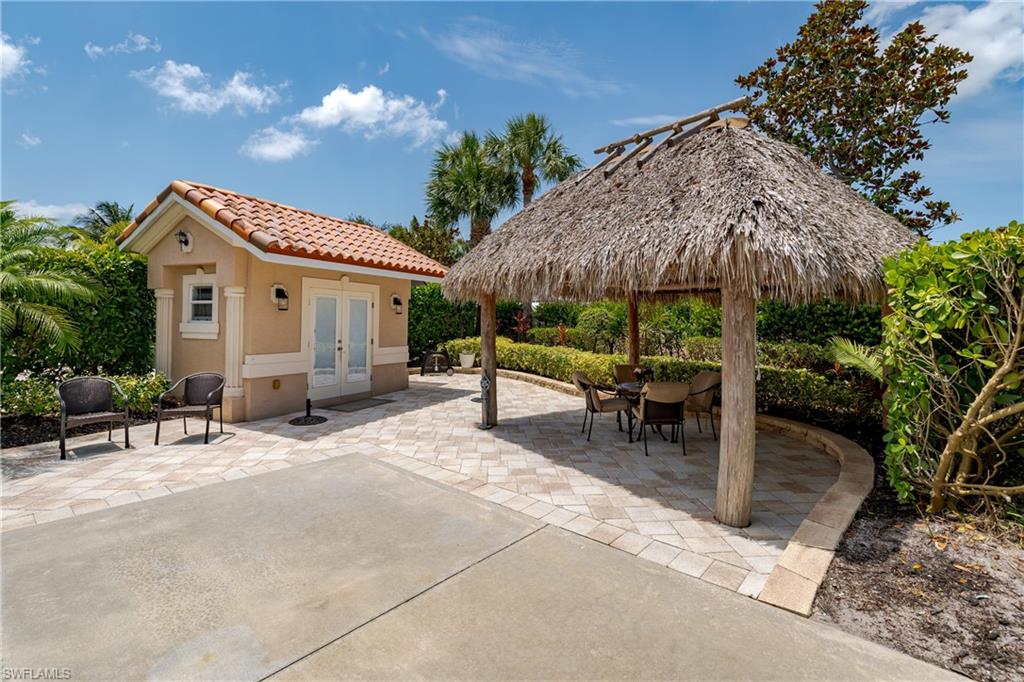a view of a patio with a table and chairs under an umbrella