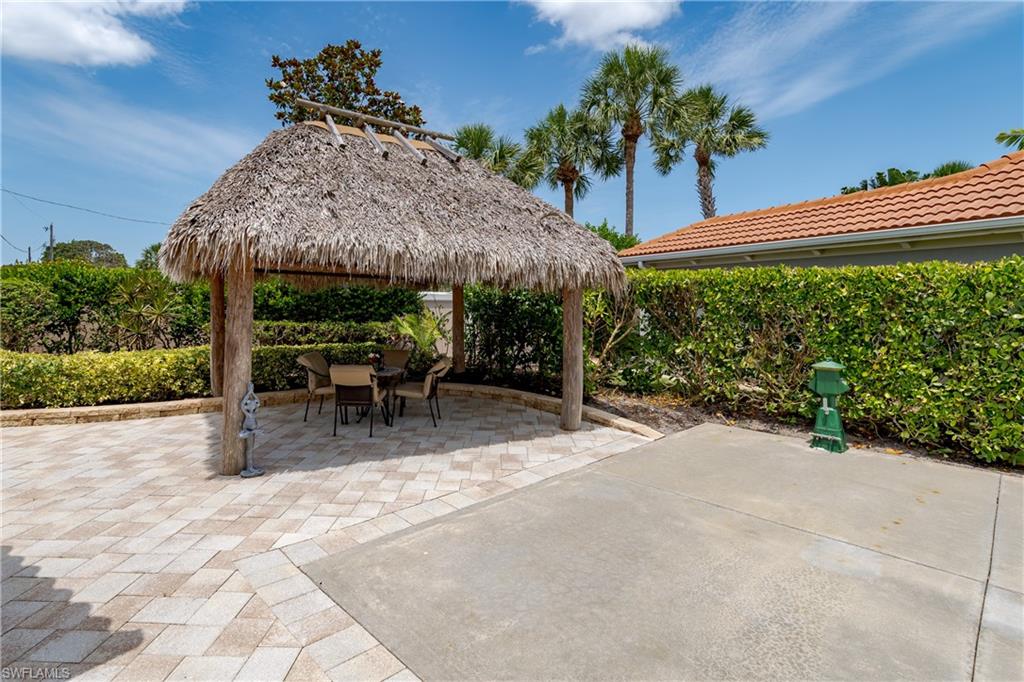 13419 Snook Circle Naples, FL 34114 - Photo 12 of 34 a view of a patio with a table and chairs under an umbrella