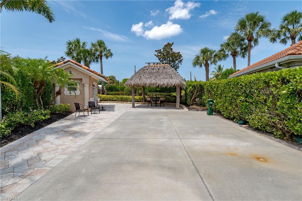 13419 Snook Circle Naples, FL 34114 - Photo 17 of 34 a view of a patio with a table and chairs under an umbrella