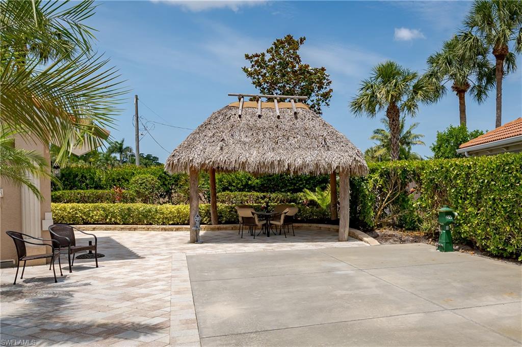 13419 Snook Circle Naples, FL 34114 - Photo 19 of 34 a view of a patio with table and chairs and potted plants