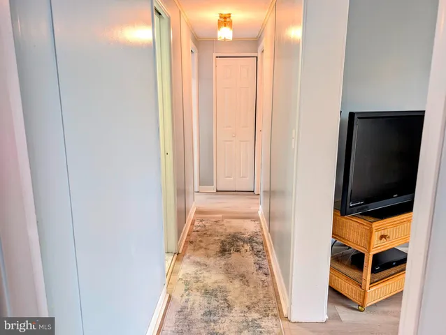 a view of a bedroom with wooden floor and white walls