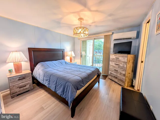 a bedroom with a bed and a flat tv screen on a dresser
