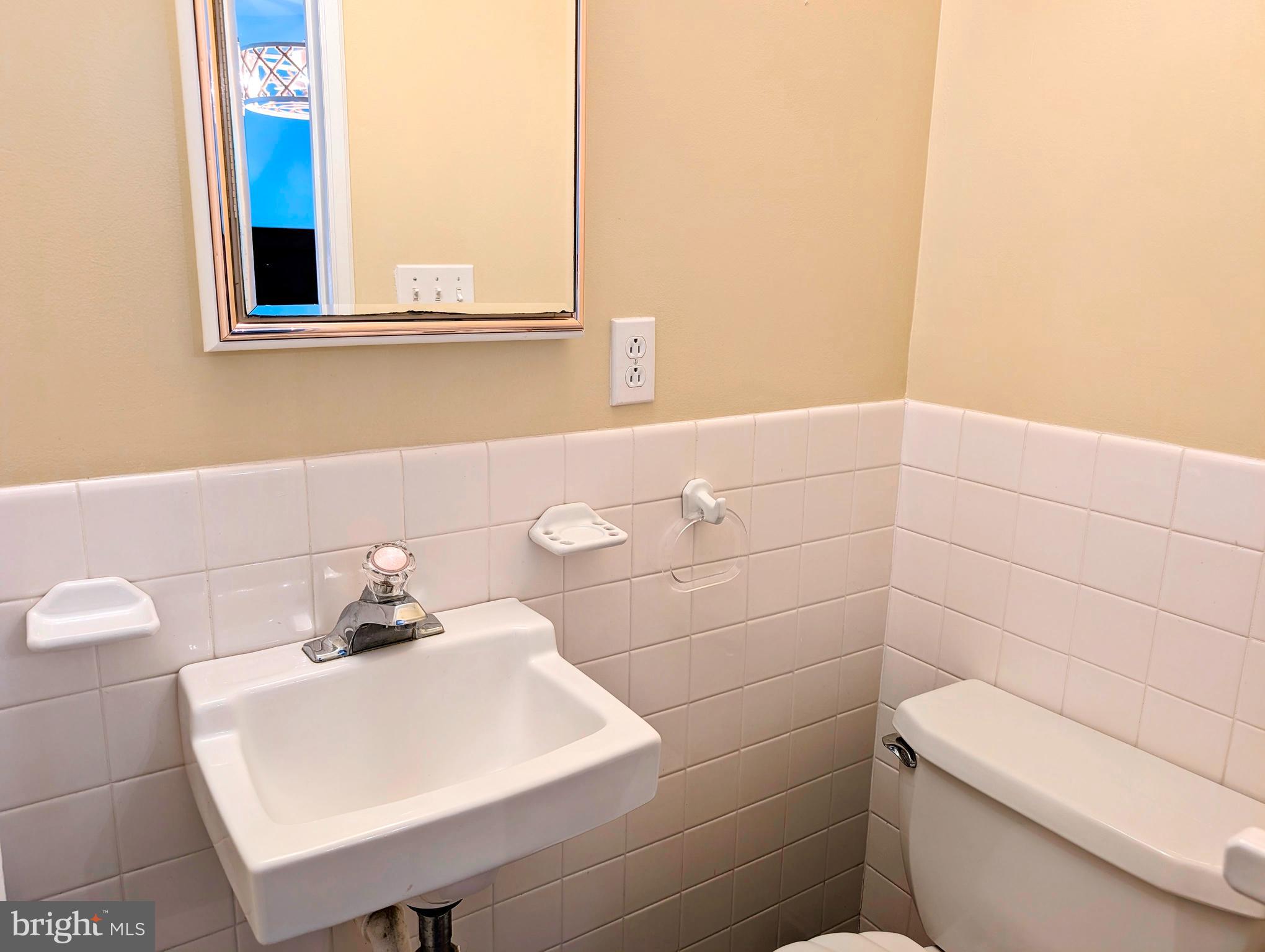 134 Captains Quarters Road, Unit 5 Ocean City, MD 21842 - Photo 22 of 26 a bathroom with a sink a toilet and a mirror