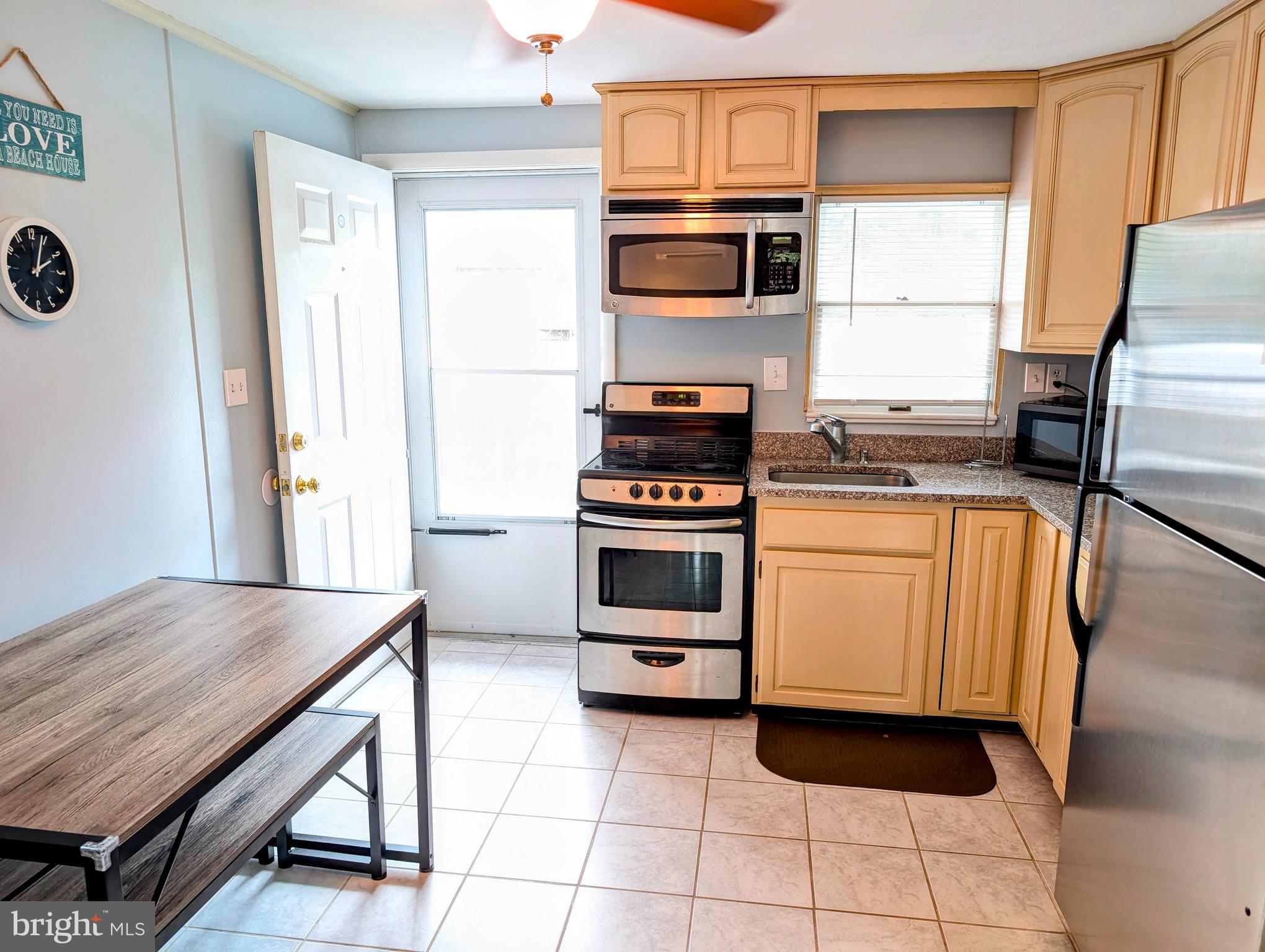 134 Captains Quarters Road, Unit 5 Ocean City, MD 21842 - Photo 8 of 26 a kitchen with a stove a sink and a refrigerator