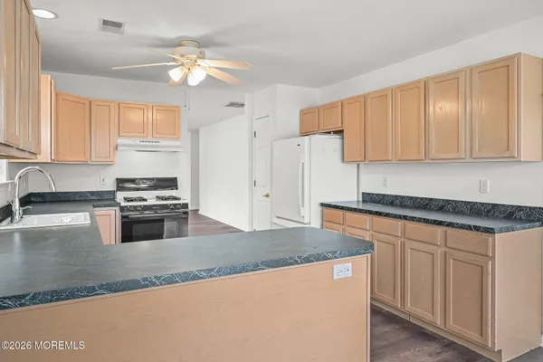a kitchen with stainless steel appliances granite countertop a stove a sink dishwasher and a refrigerator