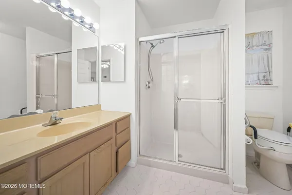 a bathroom with a shower sink vanity and toilet