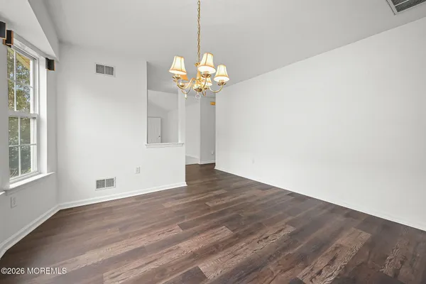 a view of a room with wooden floor and chandelier