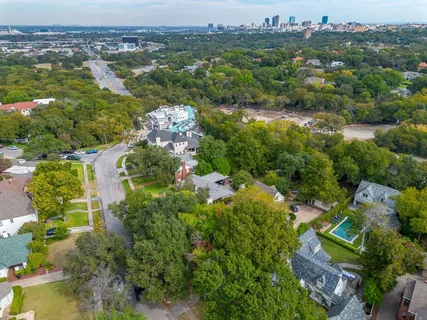 an aerial view of residential houses with outdoor space and trees