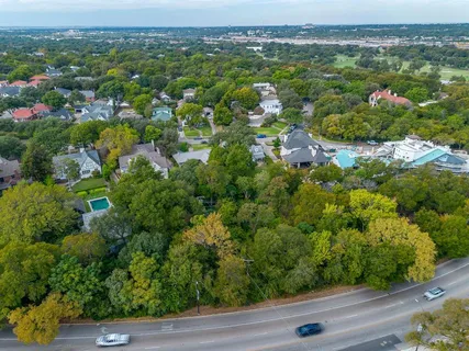 an aerial view of residential houses with outdoor space and trees