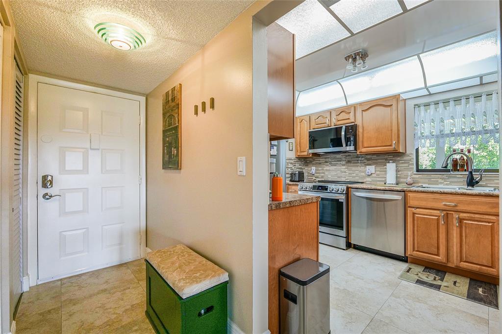 3650 Environ Boulevard, Unit 401 Lauderhill, FL 33319 - Photo 12 of 59 a kitchen with stainless steel appliances granite countertop a stove a sink and a refrigerator