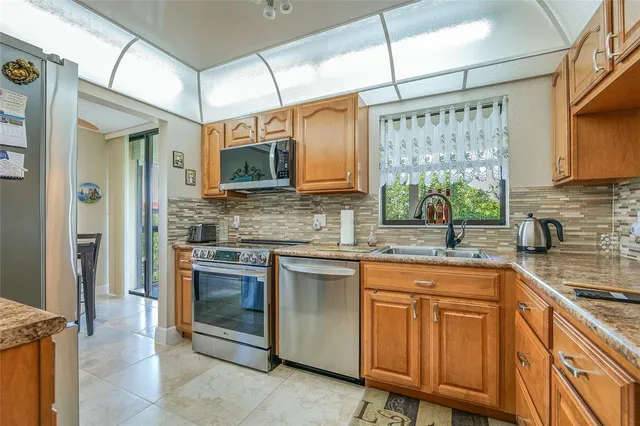 a kitchen with stainless steel appliances granite countertop a stove a sink and cabinets