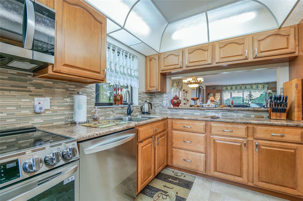 3650 Environ Boulevard, Unit 401 Lauderhill, FL 33319 - Photo 14 of 59 a kitchen with stainless steel appliances granite countertop a stove a sink and cabinets