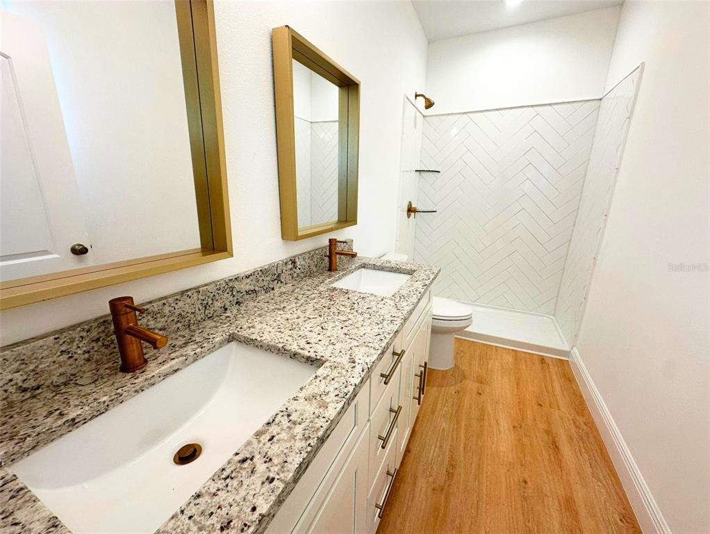 8297 Strasse Boulevard Punta Gorda, FL 33982 - Photo 15 of 31 a bathroom with a granite countertop sink a mirror and shower