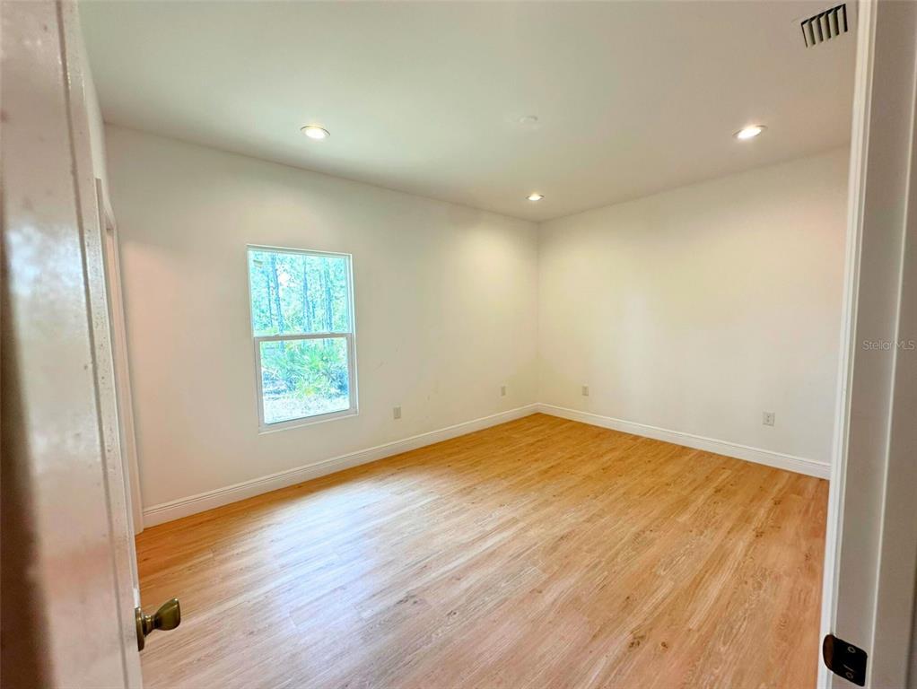 8297 Strasse Boulevard Punta Gorda, FL 33982 - Photo 21 of 31 an empty room with wooden floor and windows