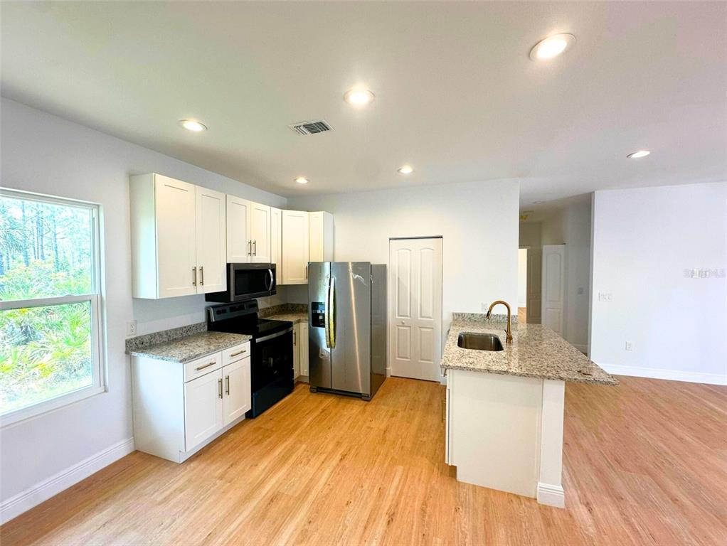 8297 Strasse Boulevard Punta Gorda, FL 33982 - Photo 5 of 31 a kitchen with refrigerator a sink a stove and wooden floor