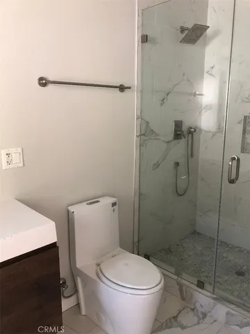 a white toilet sitting next to a shower