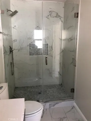 a bathroom with a shower a toilet and sink
