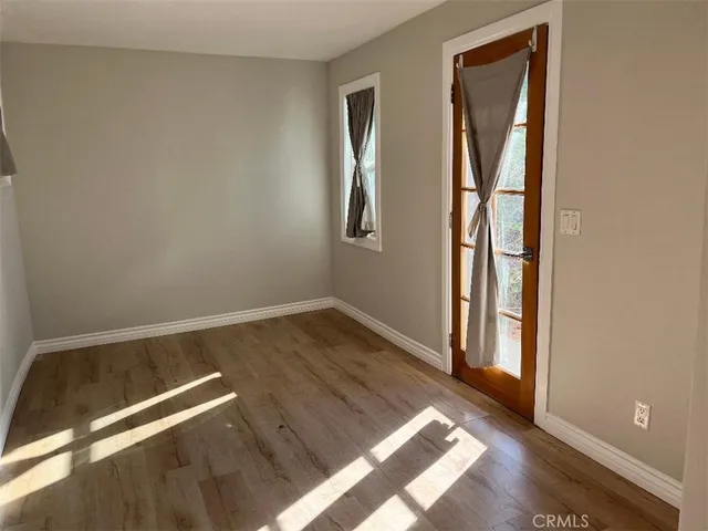 an empty room with wooden floor and closet
