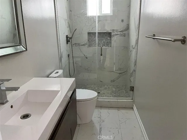 a bathroom with a sink a toilet and shower