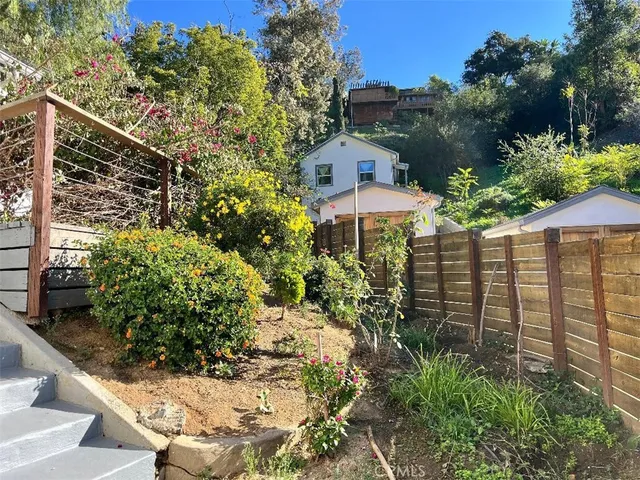 a front view of a house with a yard and fountain in middle