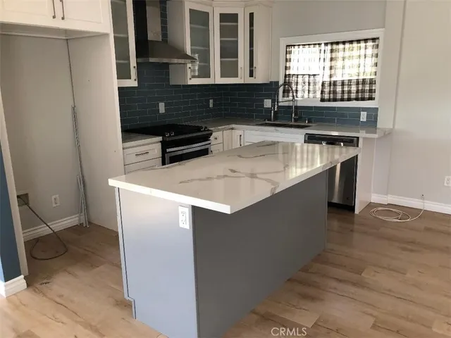 a kitchen with a sink a stove and cabinets