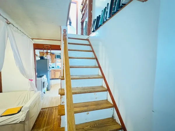 a view of entryway and hall with wooden floor