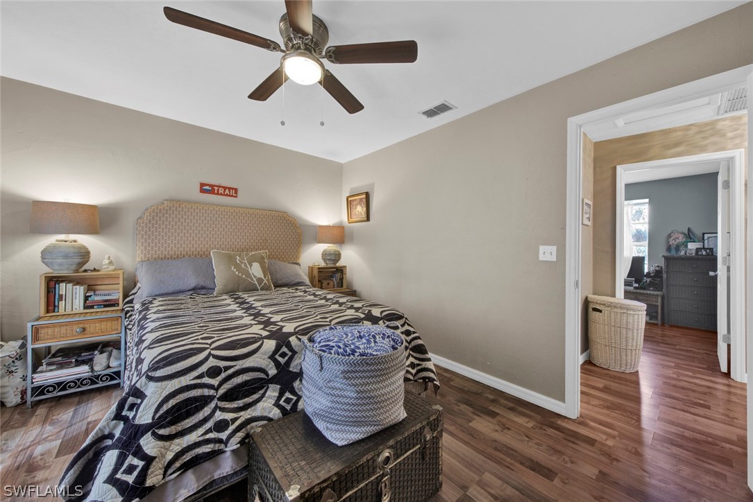 18442 Sunflower Road Fort Myers, FL 33967 - Photo 15 of 26 a bedroom with a bed and wooden floor