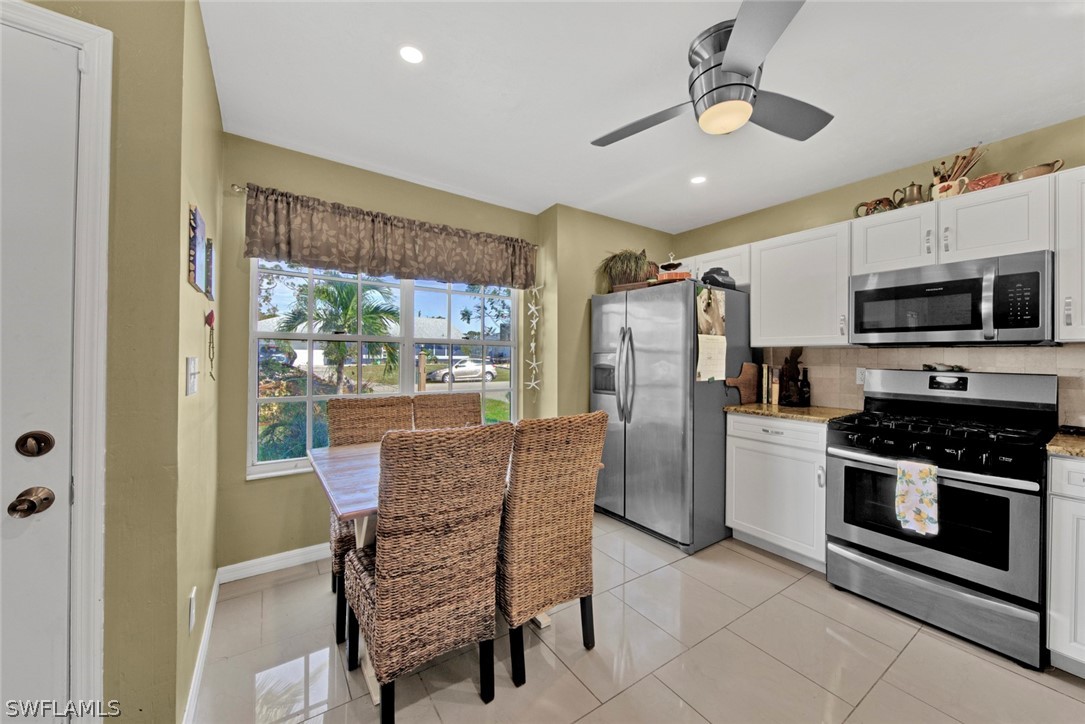 18442 Sunflower Road Fort Myers, FL 33967 - Photo 9 of 26 a dining room with furniture a flat screen tv and outdoor view