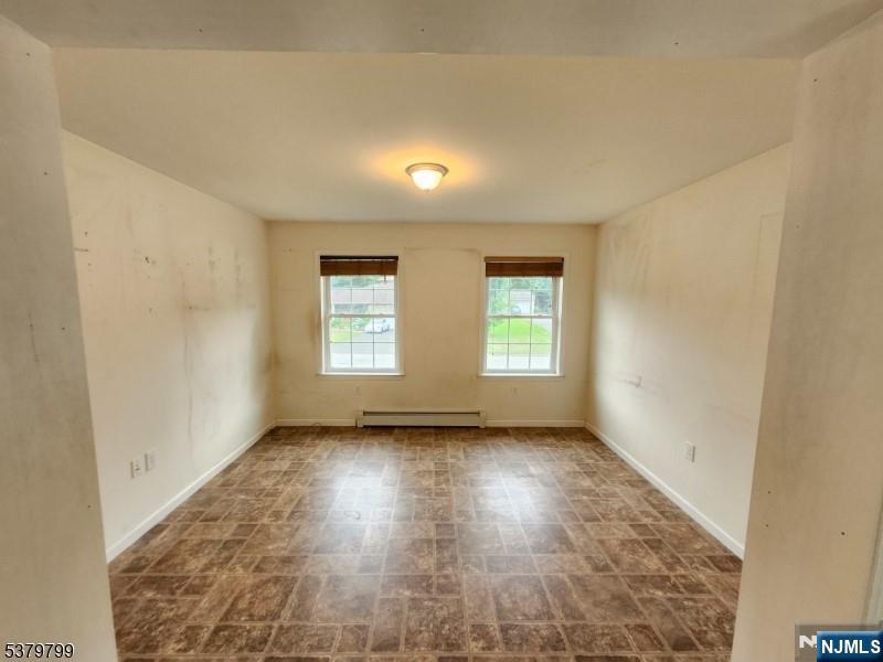 128 Big Piece Road Fairfield, NJ 07004 - Photo 15 of 26 an empty room with wooden floor and windows