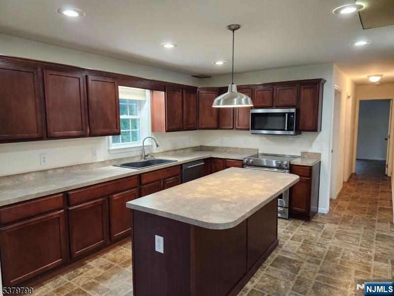 128 Big Piece Road Fairfield, NJ 07004 - Photo 4 of 26 a kitchen with kitchen island granite countertop wooden cabinets a stove a sink and a center island