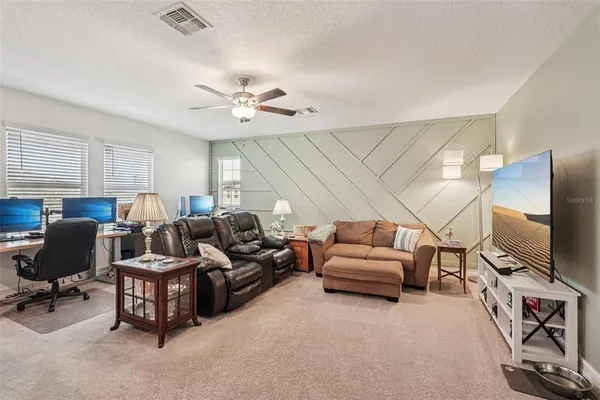 a bedroom with a bed and a flat tv screen on dresser