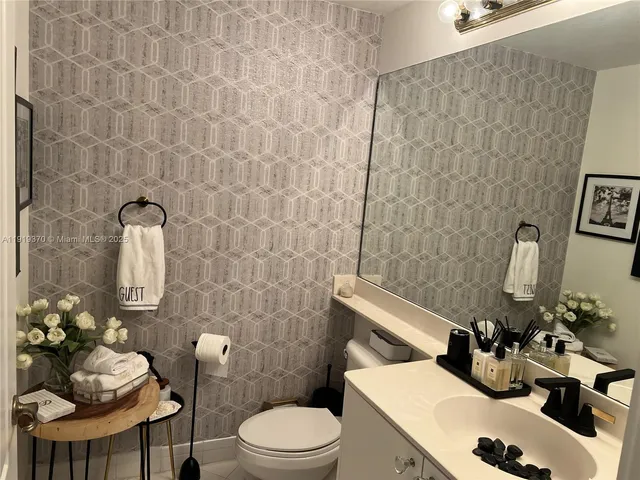 a bathroom with a sink mirror and toilet